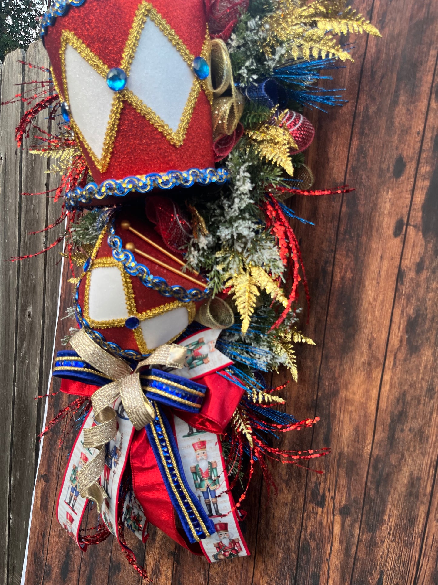 Nutcracker Drum Christmas Swag – Red, Blue & Gold Holiday Door Decor with Glitter Picks & Nutcracker Ribbon