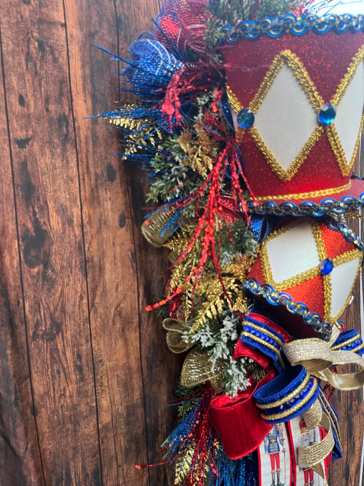 Nutcracker Drum Christmas Swag – Red, Blue & Gold Holiday Door Decor with Glitter Picks & Nutcracker Ribbon